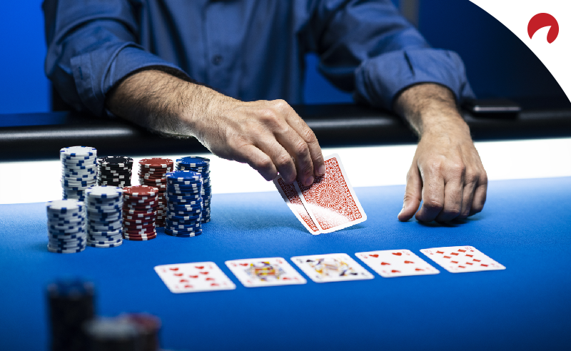 Man playing Texas Hold'em Poker with chips and community cards on blue tabletop