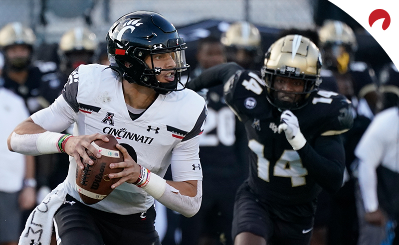 Cincinnati quarterback Desmond Ridder looks for a receiver as Central Florida defensive back Corey Thornton (14) gives chase during an NCAA college football game on Nov. 21, 2020, in Orlando, Fla.