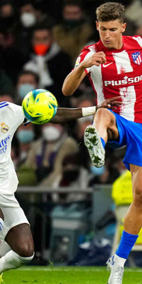 Vinicius (izq) y Llorente disputan un balón en un derbi. Descubre los pronósticos del Atlético De Madrid Vs Real Madrid.