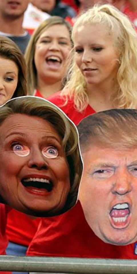 Fans at a Kansas City Chiefs football game hold up cut-outs of Donald Trump and Hillary Clinton.