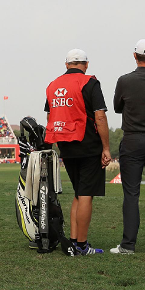 Justin Rose of England and caddie Mark Fulcher prepares to play a shot on the 18th hole during the final round of the WGC - HSBC Champions at Sheshan International Golf Club on October 29, 2017 in Shanghai, China.