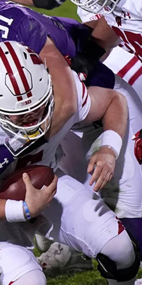 Wisconsin quarterback Graham Mertz (5) is sacked by Northwestern cornerback Cam Ruiz, left, and linebacker Blake Gallagher during an NCAA college football game in Evanston, Ill., on Nov. 21, 2020.