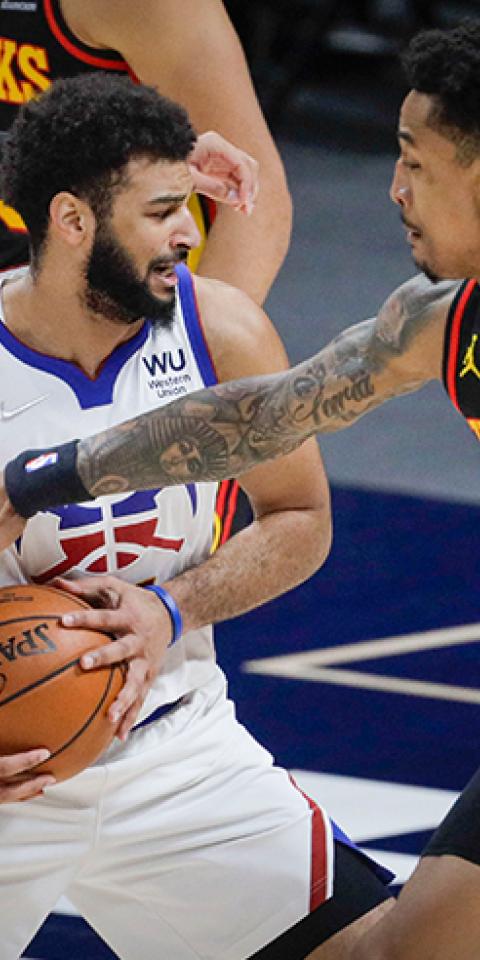 Jamal Murray esconde el balón ante dos rivales. Descubre las cuotas para el Nuggets Vs 76ers de la NBA.