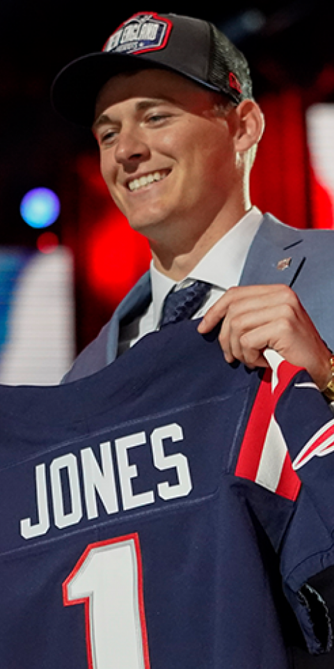 New England Patriots quarterback odds come down to rookie Mac Jones, pictured at the 2021 NFL Draft, and veteran Cam Newton.