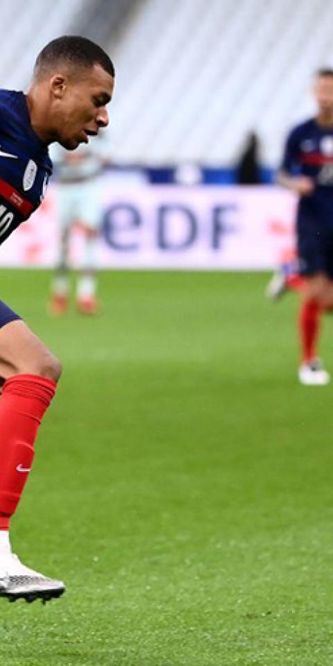 Kylian Mbappé trata de controlar un balón con la camiseta de Francia. Conoce los pronósticos para el Francia Vs Gales.
