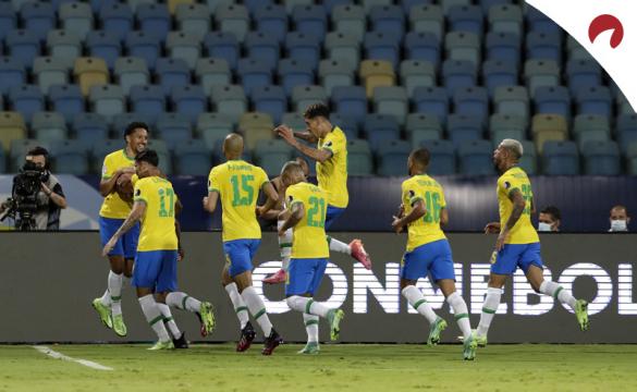 Eder Militao celebra un gol junto a sus compañeros de la Canarinha. Cuotas y picks Brasil vs Chile.