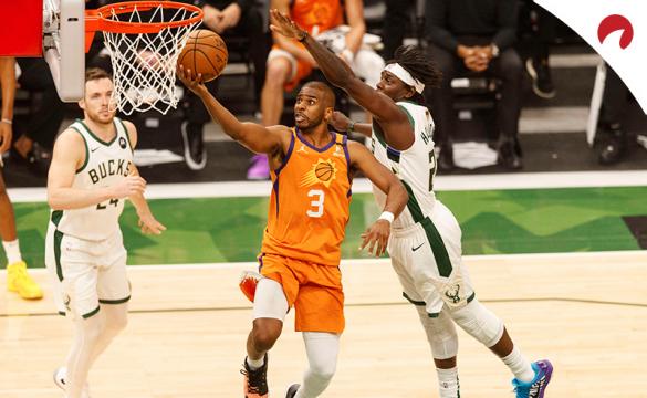 Chris Paul (izquierda) anota ante Jrue Holiday en las finales de la NBA. Conoce los pronósticos del Suns vs Bucks.